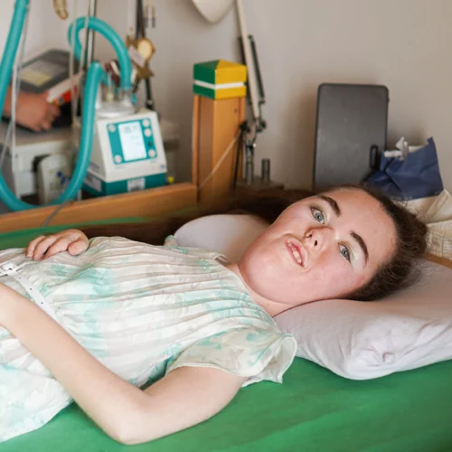 Emma im Bett liegend und in die Kamera schauend