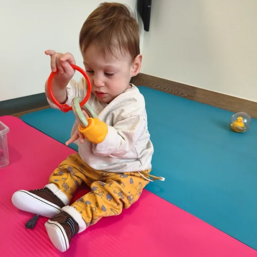 Remus aus Regensburg spielt sitzend auf dem Boden.